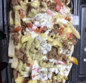 Asada fries con salsas y tomate y cebolla picados