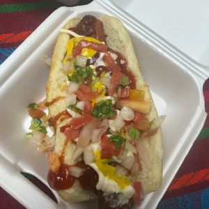 Hot dog con tomate, cebolla, cilantro, mostaza y cátsup