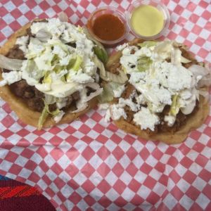 Dos sopes con carne, lechuga y queso blanco, con dos salsas